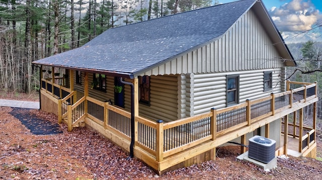 rear view of property featuring a wooden deck and central AC