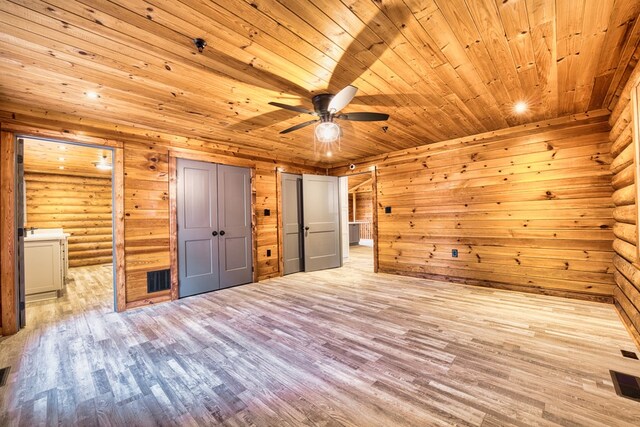 unfurnished bedroom featuring ceiling fan, log walls, wooden ceiling, and light hardwood / wood-style floors