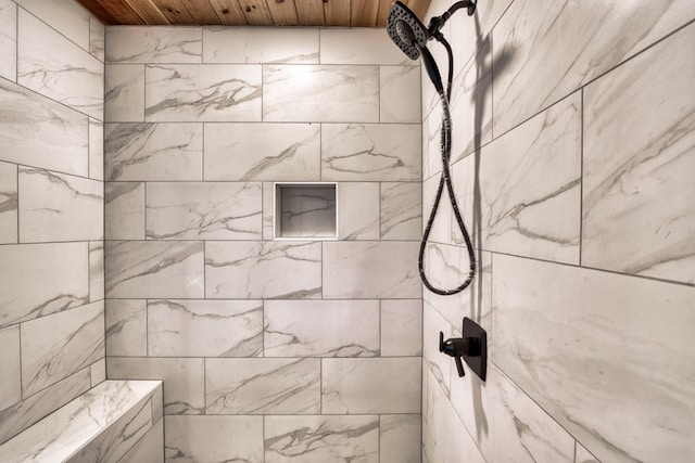 bathroom with a tile shower and wooden ceiling