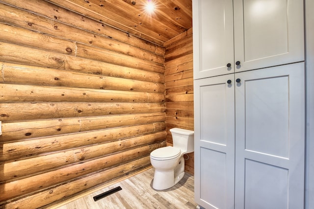 bathroom featuring log walls, hardwood / wood-style flooring, toilet, and wood ceiling