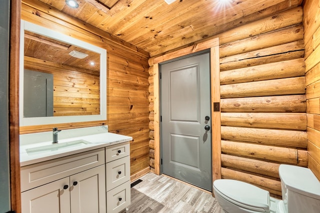 bathroom featuring log walls, toilet, vanity, wood ceiling, and hardwood / wood-style flooring