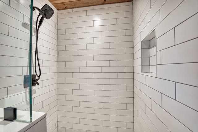 bathroom featuring tiled shower and wooden ceiling