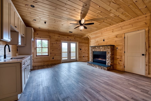 unfurnished living room with a fireplace, light wood-type flooring, wooden ceiling, and sink