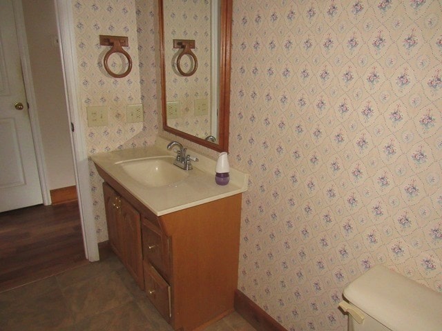 bathroom with hardwood / wood-style floors, vanity, and toilet