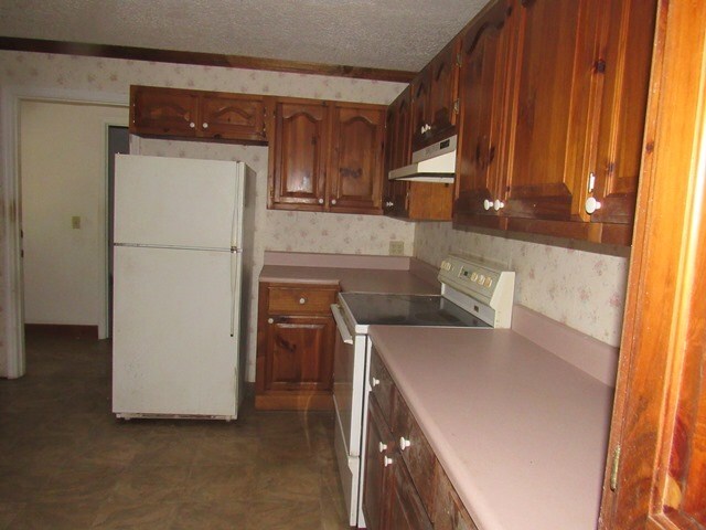 kitchen with a textured ceiling and white appliances