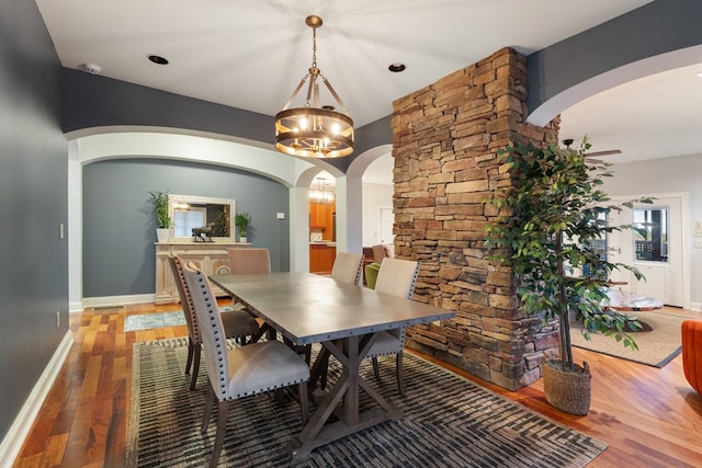 dining area with wood-type flooring and a chandelier