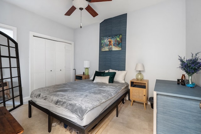 carpeted bedroom featuring ceiling fan and a closet