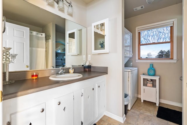 bathroom with stacked washer / drying machine and vanity