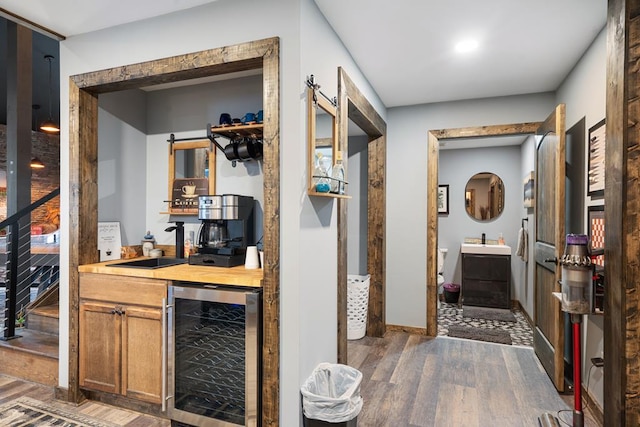 corridor featuring dark hardwood / wood-style flooring, sink, and beverage cooler