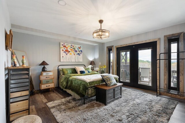 bedroom featuring french doors, access to outside, dark hardwood / wood-style flooring, and a chandelier