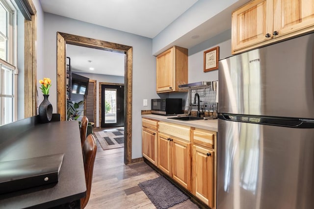 kitchen with light brown cabinets, dark hardwood / wood-style flooring, sink, and appliances with stainless steel finishes