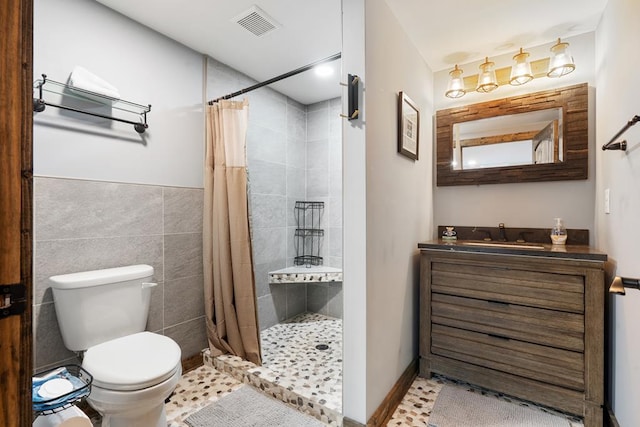 bathroom with toilet, tile patterned floors, tile walls, vanity, and a shower with shower curtain