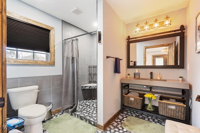 bathroom with toilet, a shower with curtain, tile walls, and tile patterned floors