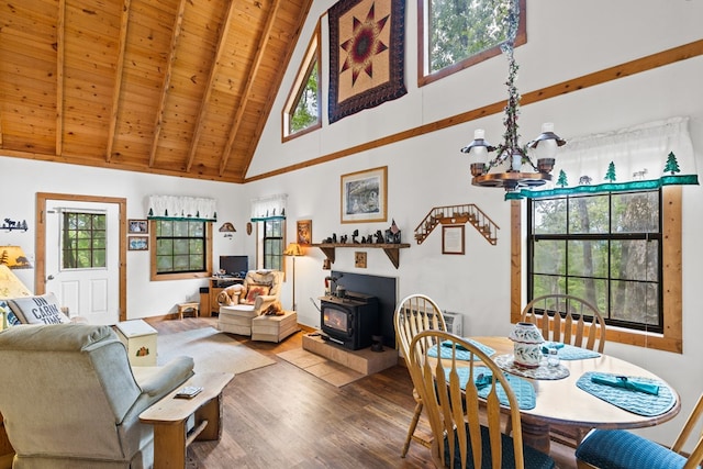 dining room with beam ceiling, a wood stove, wooden ceiling, hardwood / wood-style flooring, and high vaulted ceiling