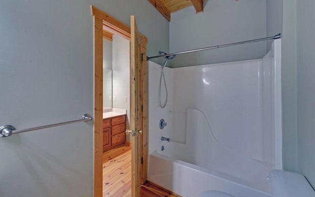 bathroom featuring beam ceiling, vanity, wood-type flooring, and shower / bathtub combination