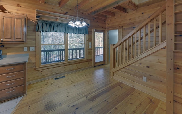 unfurnished dining area featuring light hardwood / wood-style flooring and wood walls