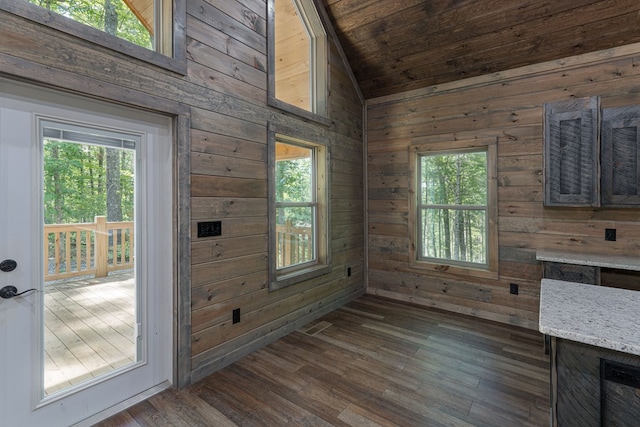 unfurnished dining area with wood walls, lofted ceiling, dark hardwood / wood-style floors, and wood ceiling