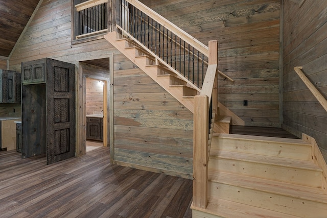 stairway featuring wood walls, wooden ceiling, vaulted ceiling, and wood-type flooring