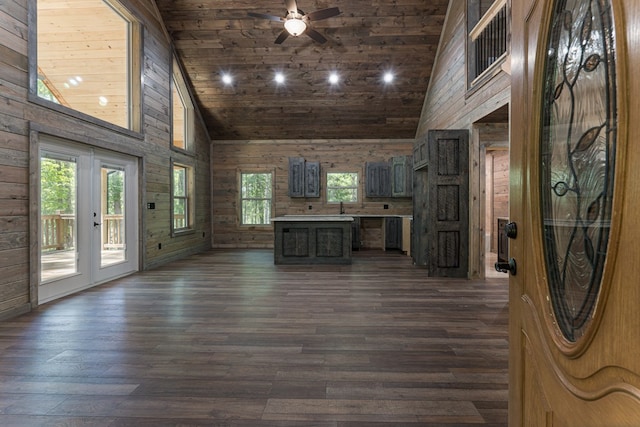 unfurnished living room with high vaulted ceiling, dark hardwood / wood-style flooring, wooden walls, and wood ceiling