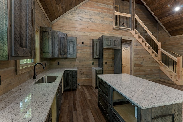 kitchen featuring wooden ceiling, wooden walls, sink, and vaulted ceiling