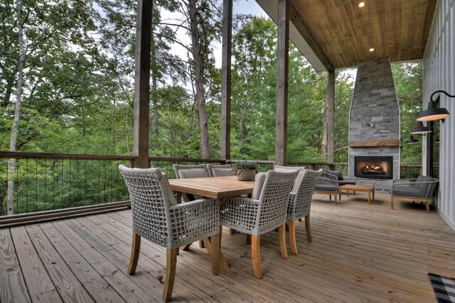 sunroom featuring wooden ceiling and an outdoor stone fireplace