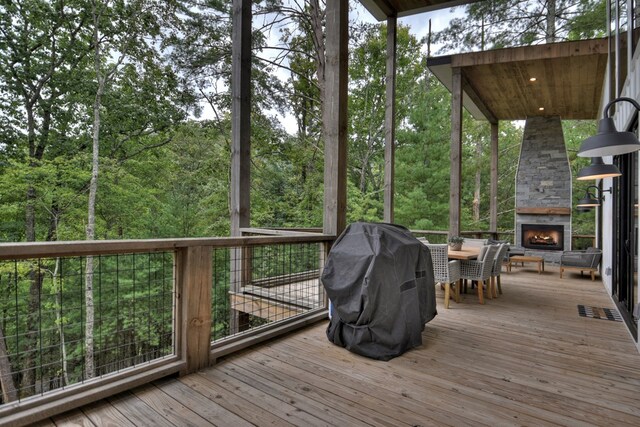 deck with grilling area and an outdoor stone fireplace