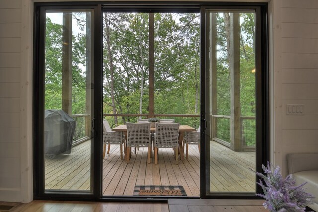 entryway featuring light wood-type flooring, plenty of natural light, and wooden walls