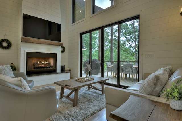 living room with a towering ceiling and wooden walls