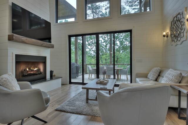 living room with light wood-type flooring and a high ceiling