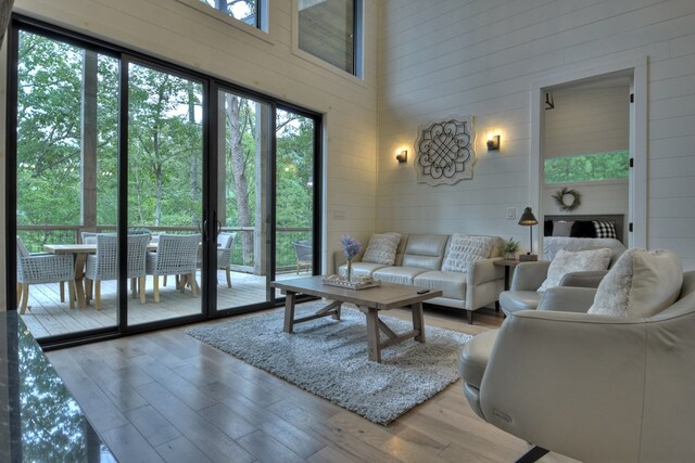 living room with a towering ceiling and wood-type flooring