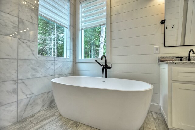 bathroom featuring vanity, hardwood / wood-style floors, and a washtub