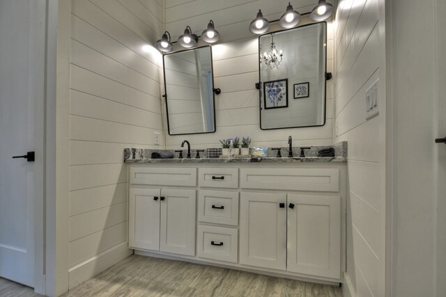 bathroom featuring vanity, wood walls, and hardwood / wood-style floors