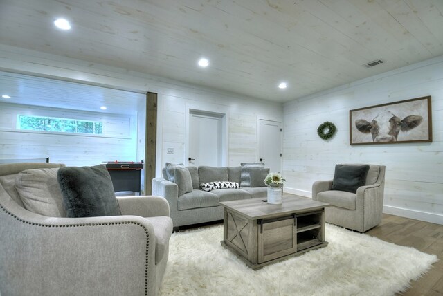 living room featuring light wood-type flooring and wooden walls