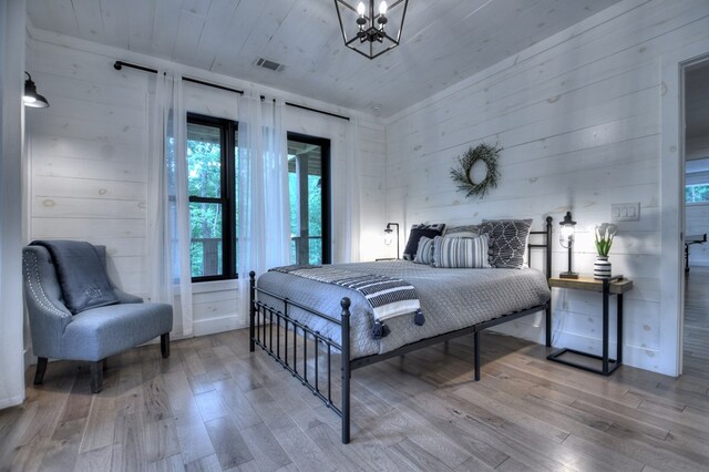 bedroom with wood ceiling, wood walls, and wood-type flooring