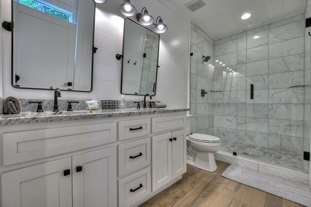 bathroom featuring a shower with door, vanity, toilet, and wood-type flooring