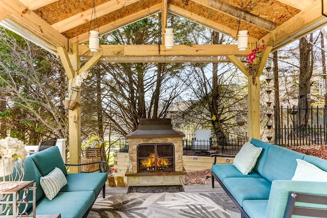 exterior space with an outdoor stone fireplace and vaulted ceiling