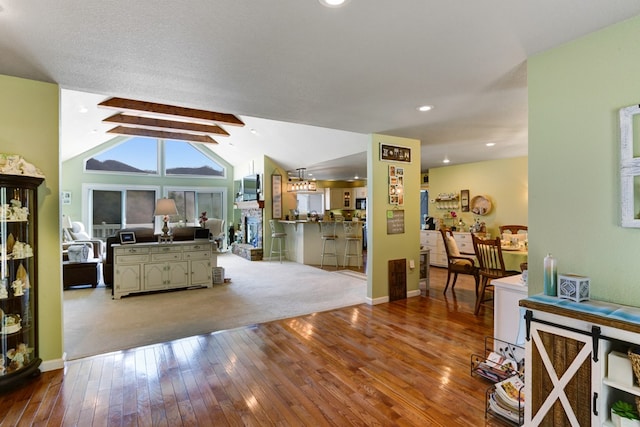 living room featuring vaulted ceiling with beams and wood-type flooring