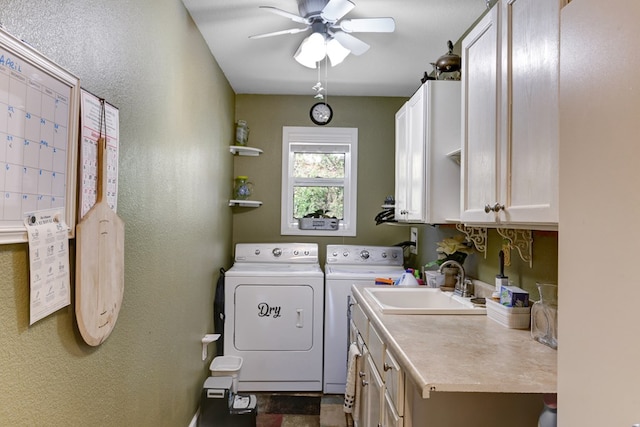 clothes washing area with ceiling fan, cabinets, sink, dark tile flooring, and independent washer and dryer