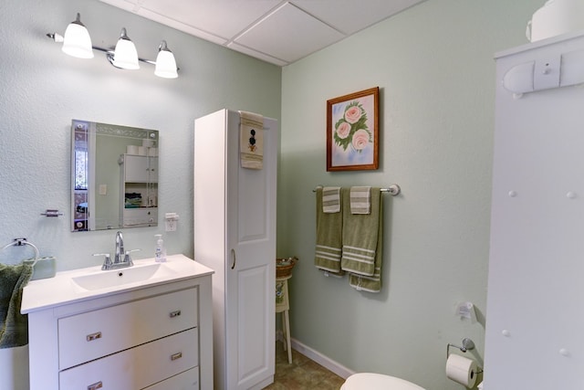 bathroom featuring tile floors, large vanity, and a paneled ceiling