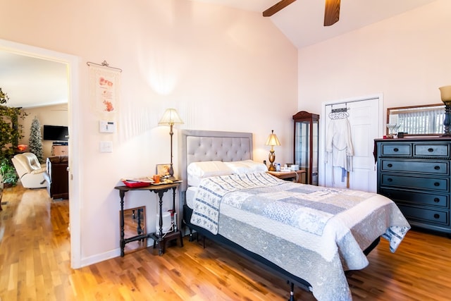 bedroom featuring high vaulted ceiling, baseboards, and wood finished floors