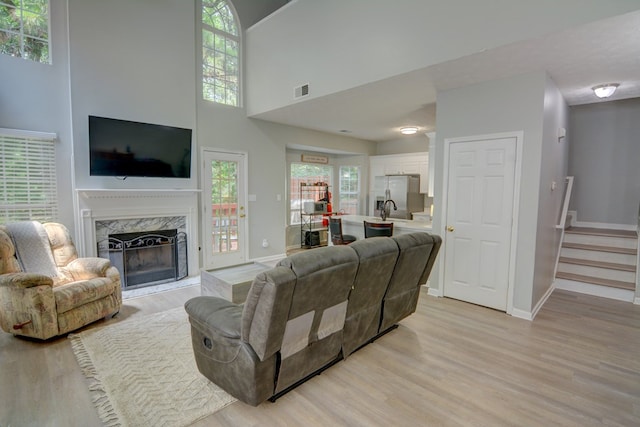 4149 Spring Cove Dr, Duluth, GA 30097 - living room with light wood-style flooring, a fireplace, baseboards, a high ceiling, and stairs