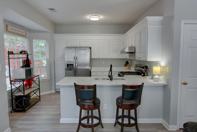 4149 Spring Cove Dr, Duluth, GA 30097 - kitchen featuring stainless steel fridge with ice dispenser, under cabinet range hood, a sink, range, and a peninsula