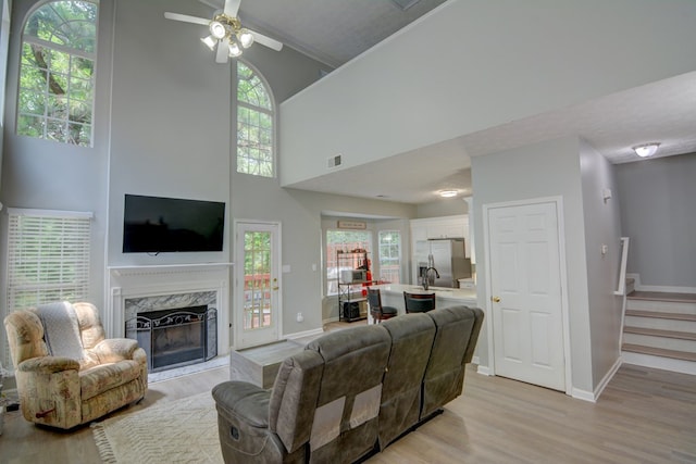 4149 Spring Cove Dr, Duluth, GA 30097 - living area with light wood-type flooring, a premium fireplace, a ceiling fan, stairway, and baseboards