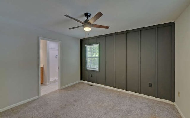 unfurnished bedroom featuring light colored carpet, baseboards, and ceiling fan