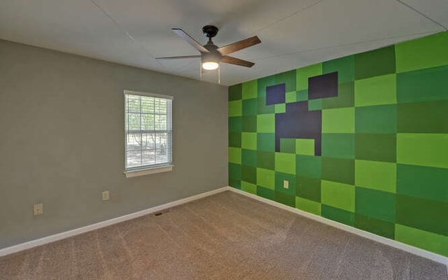 carpeted spare room with ceiling fan and baseboards