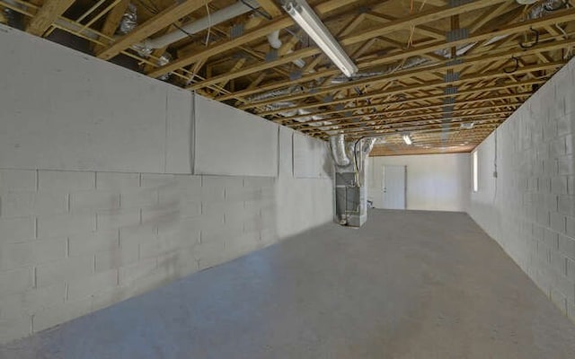 unfinished below grade area with concrete block wall and heating unit