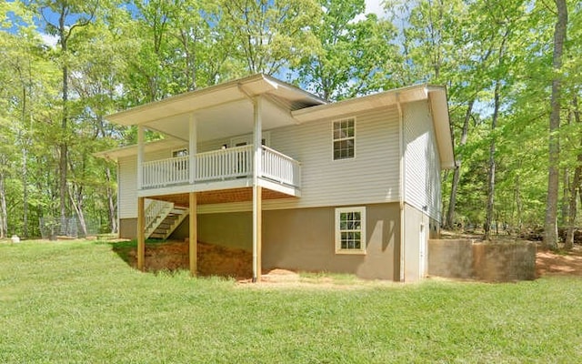 rear view of house with a wooden deck, stairs, and a yard