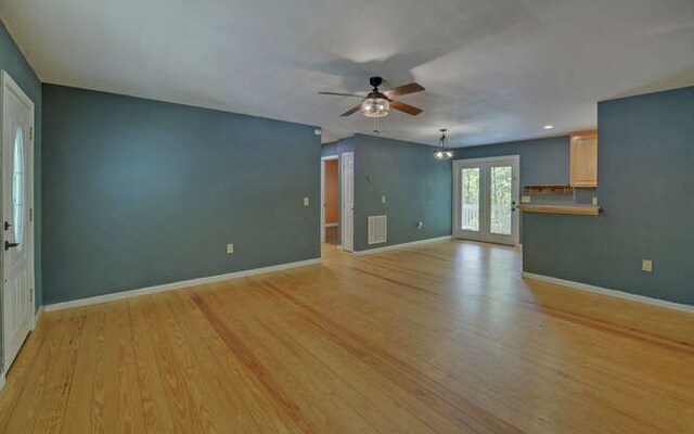 empty room featuring a ceiling fan, baseboards, french doors, and light wood finished floors