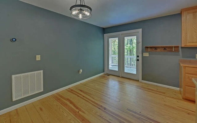 doorway with baseboards, visible vents, and light wood-style floors