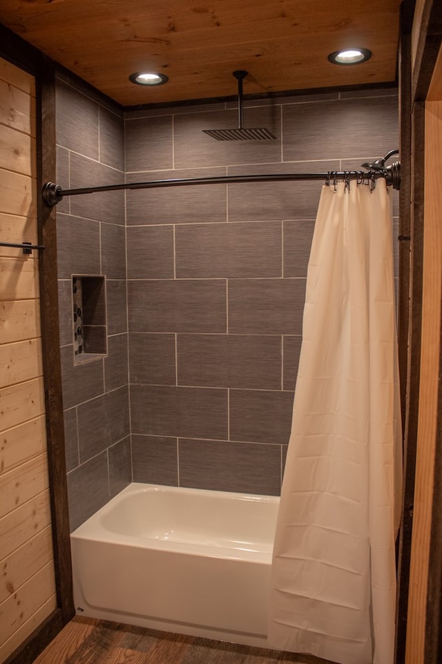 bathroom featuring wood-type flooring, shower / tub combo with curtain, and wooden ceiling